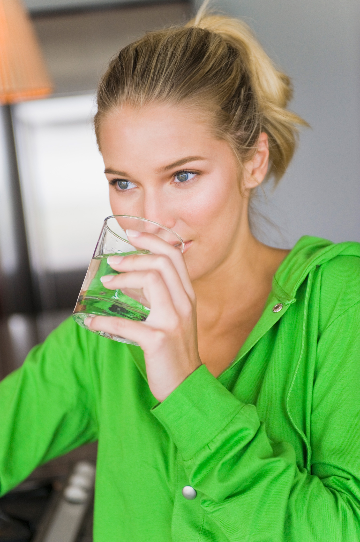 Egy zöld pulóveres egy pohár vizet iszik