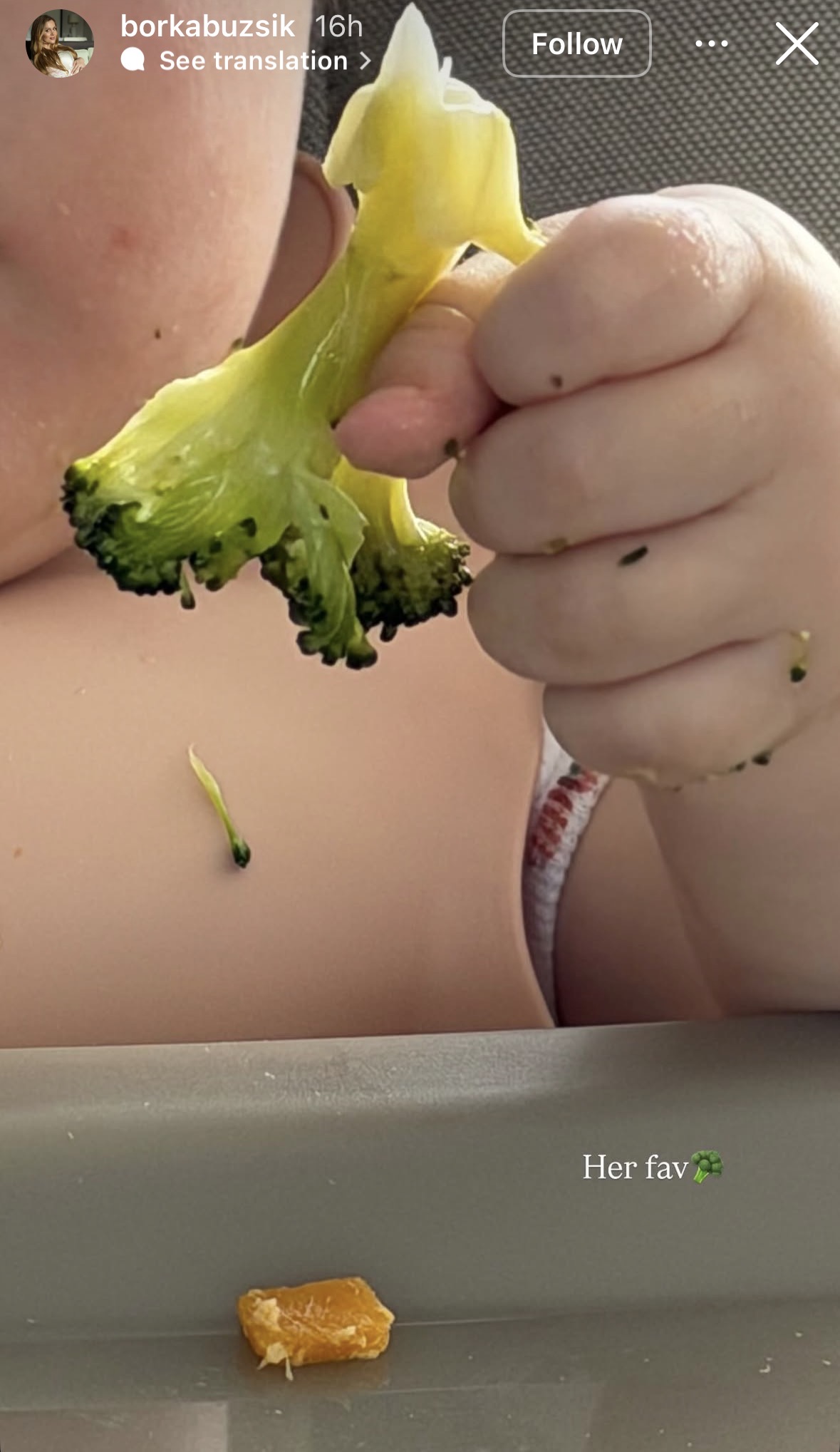 kisbaba kezében brokkoli, közeli részlet