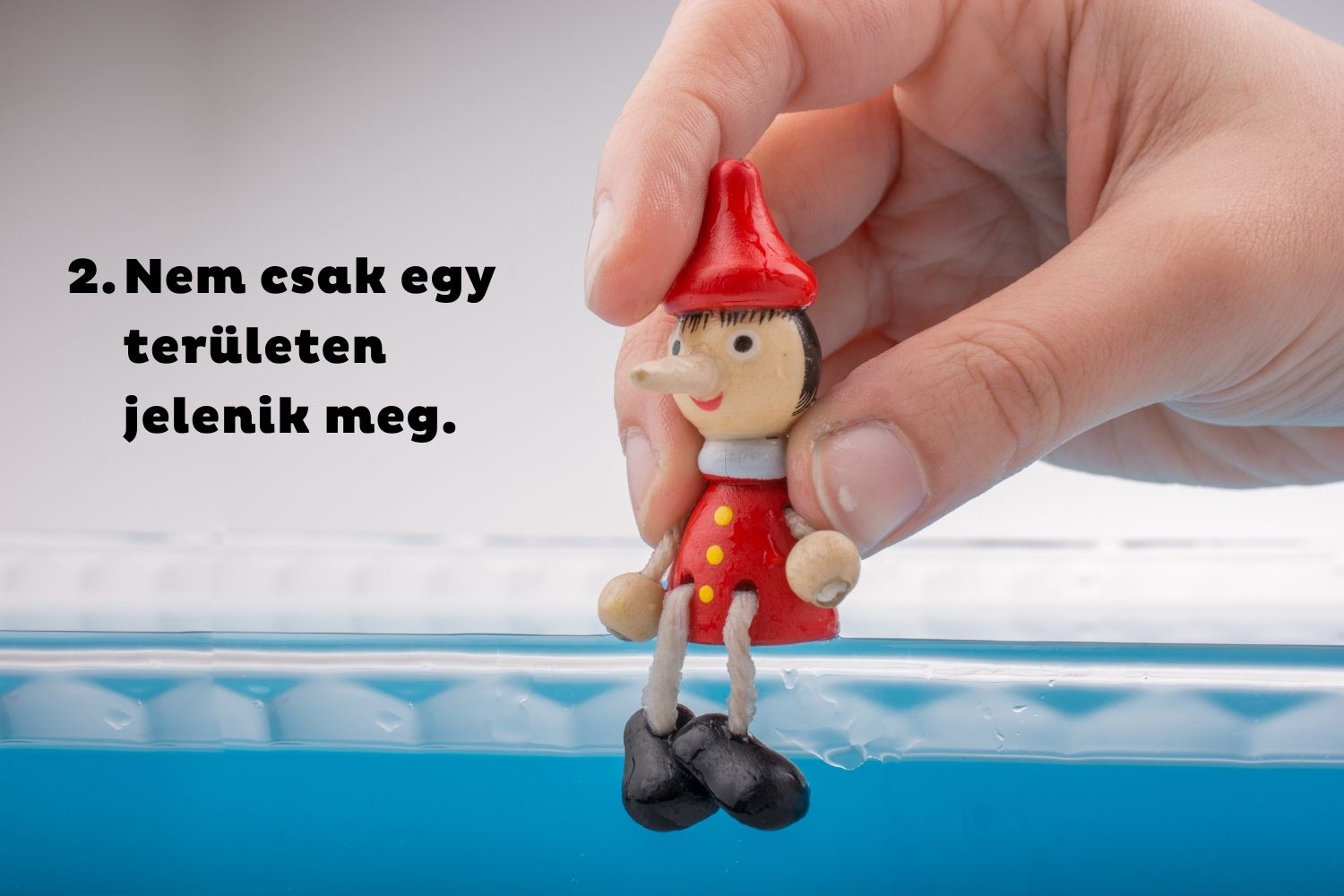 Pinokkió bábut ültet kéz kék szegélyre