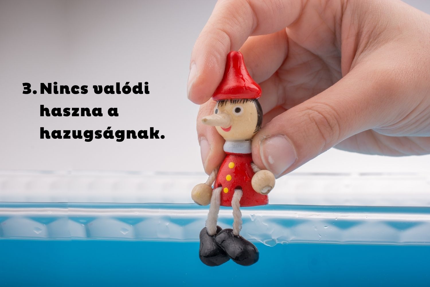 Pinokkió bábut ültet kéz kék szegélyre