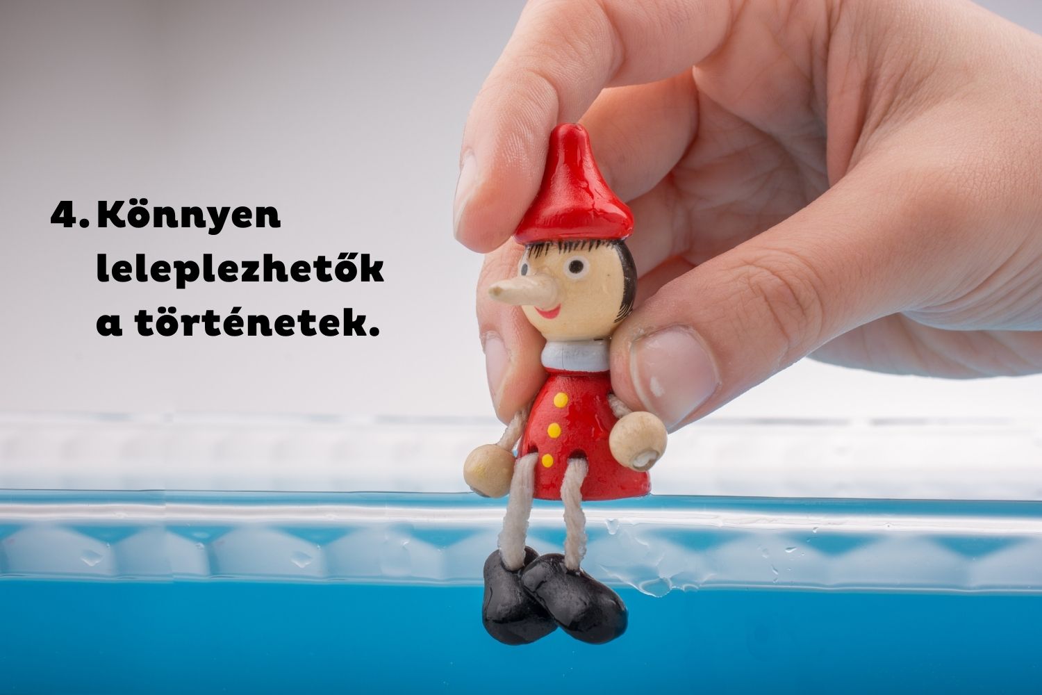 Pinokkió bábut ültet kéz kék szegélyre