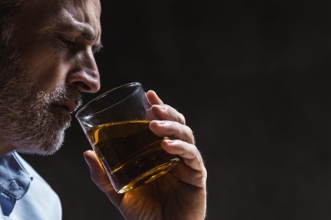 Egy férfi egy pohár whisky-t iszik