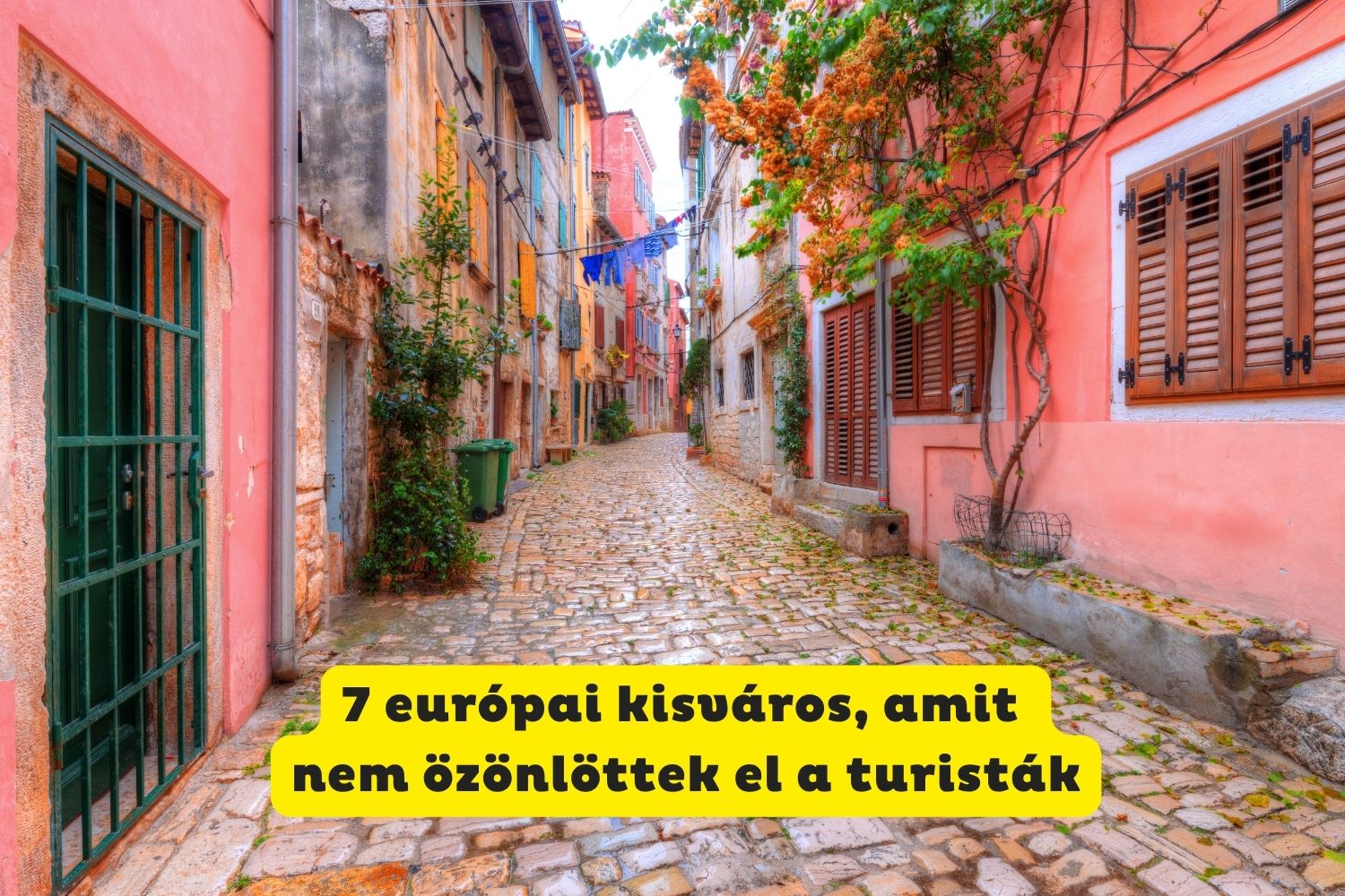 Olasz kisváros macskaköves utcácskája, mindkét oldalon rózsaszínre meszelt házak, felfuttatott virágok