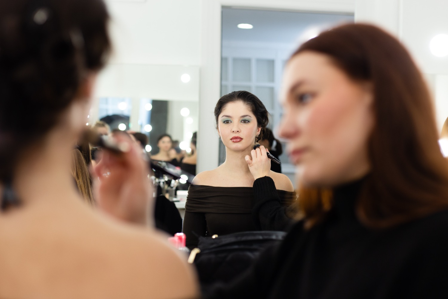 Glossy lips trend sminkelés, a sminkes látszik és a modell a tükörben