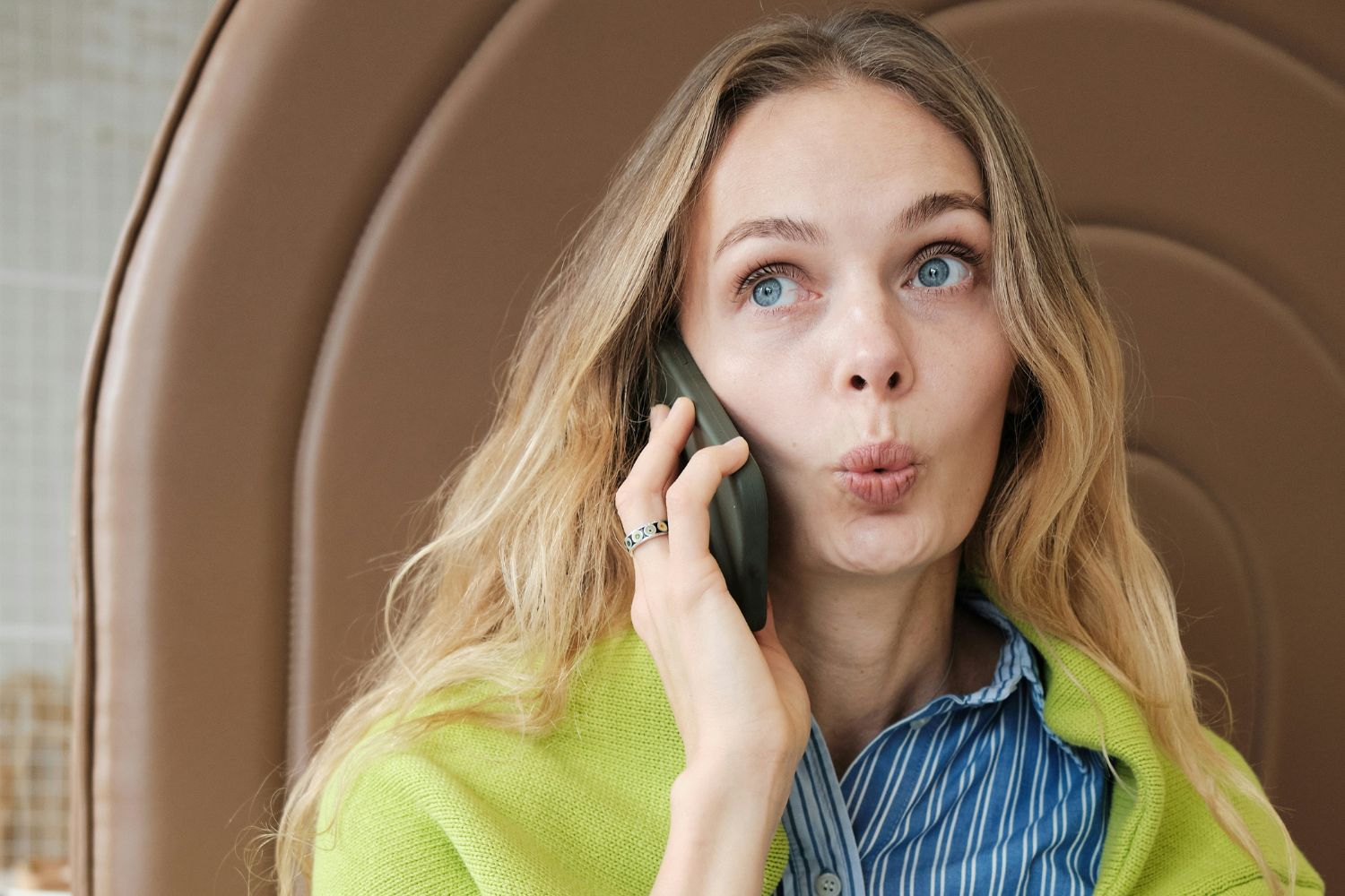 Nő csücsírtve grimaszol telefonálás közben