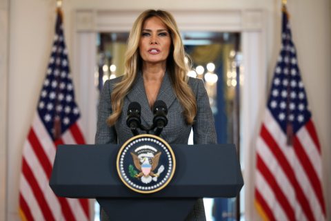 Melania Trump szürke kosztümben beszédet mond a kamerák előtt a Fehér Házban