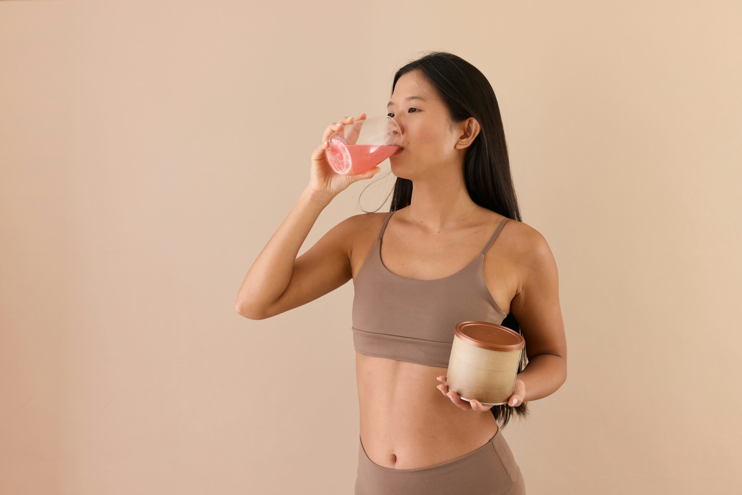 Szép fiatal lány vitamint vesz be sportruházatban