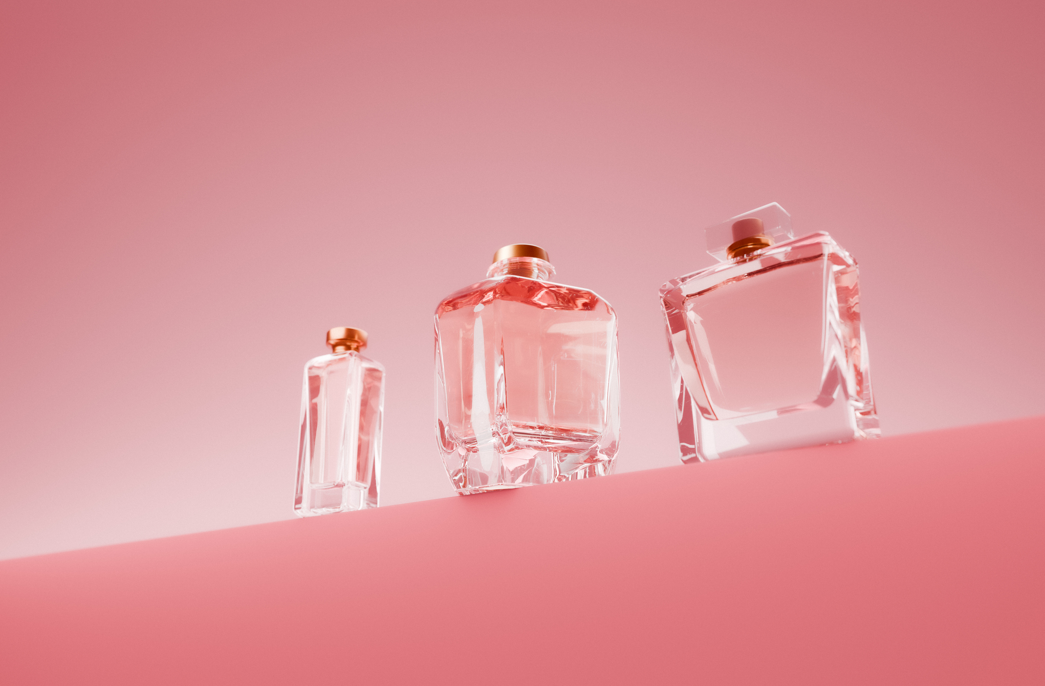 parfümös üvegek rózsaszín háttéren