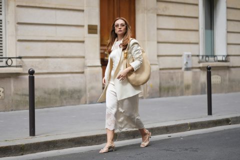 Merve Gorgoz hosszú, hullámos, világosbarna, középen elválasztott hajat visel, natúr sminket határozott szemöldökkel és nude rúzzsal, keret nélküli Tiffany & Co. napszemüveget, törtfehér The Frankie Shop oversized blézert bevágott hajtókával egy krémfehér Malina midiruha fölött, amelynek a felsőrészén és az alján csipke berakás található, arany ékszereket, egy bézs Schiaparelli nagyméretű bőr válltáskát arany szem díszítéssel, valamint bézs Parallele pántos magas sarkú cipőt