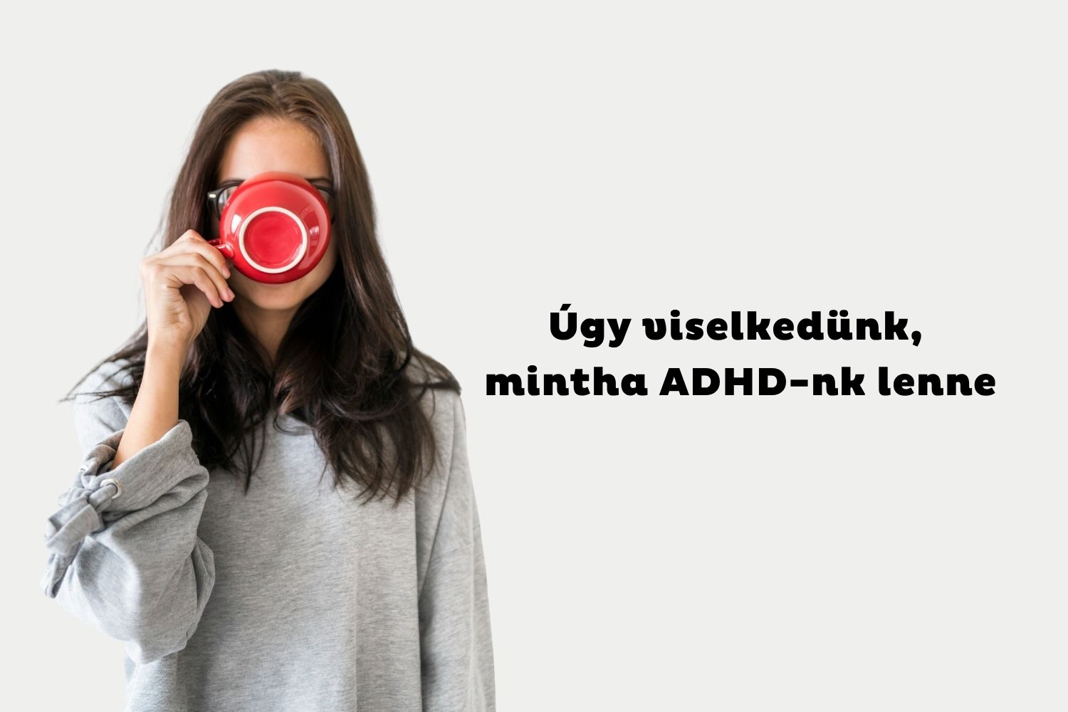 Szürke pulcsis, hosszú, barna hajú nő piros kávéscsészét emel a szájához