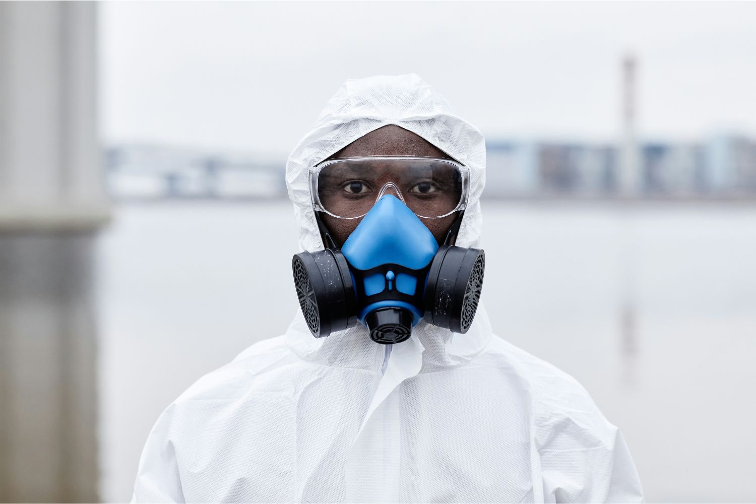 Afrikai férfi ebola-járvány miatt fehér védőruhában és kék légzőmaszkkal steril környezetben