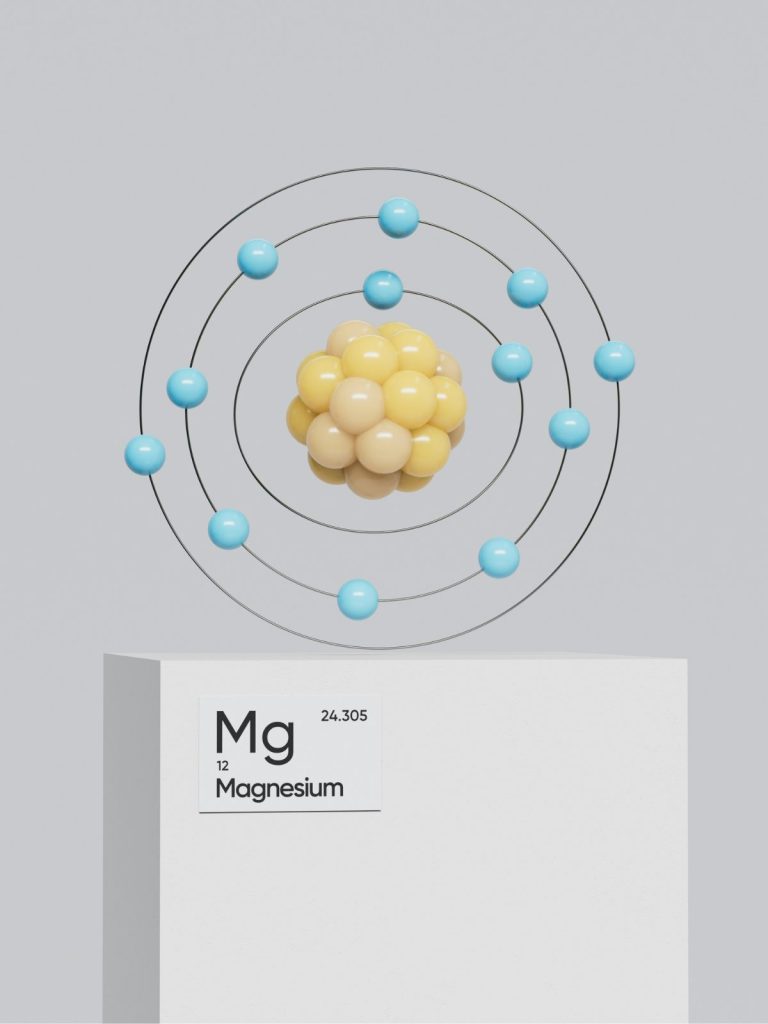 magnezium | Marie Claire Magnézium molekula modellje fehér doboz felett, amin a magnézium vegyjele van írva