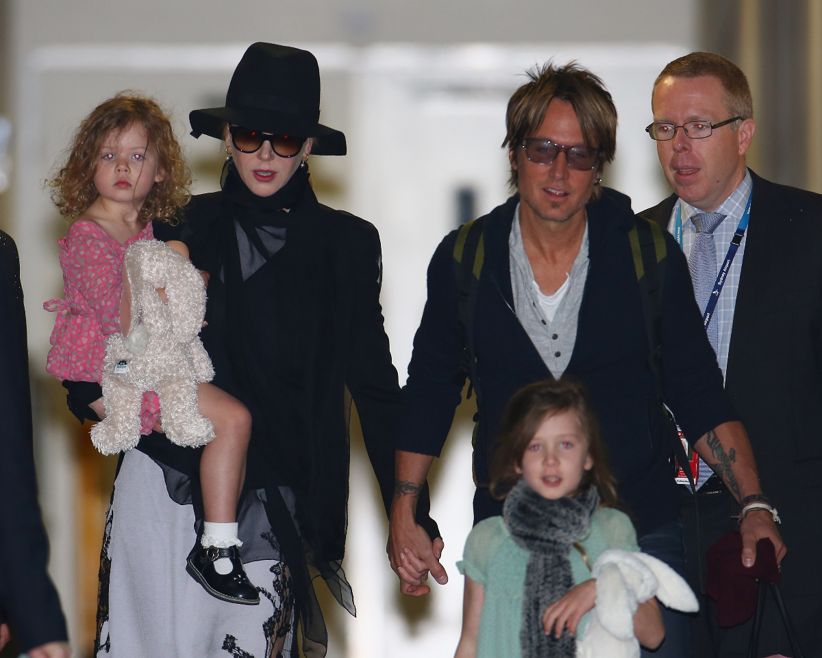 Nicole Kidman kalapban, mellette Keith Urban, aki a kezét fogja. kisgyerekeikkel 2014-ben