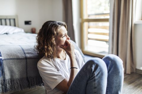 Egy depressziós fiatal felnőtt nő, aki egyedül ül otthon