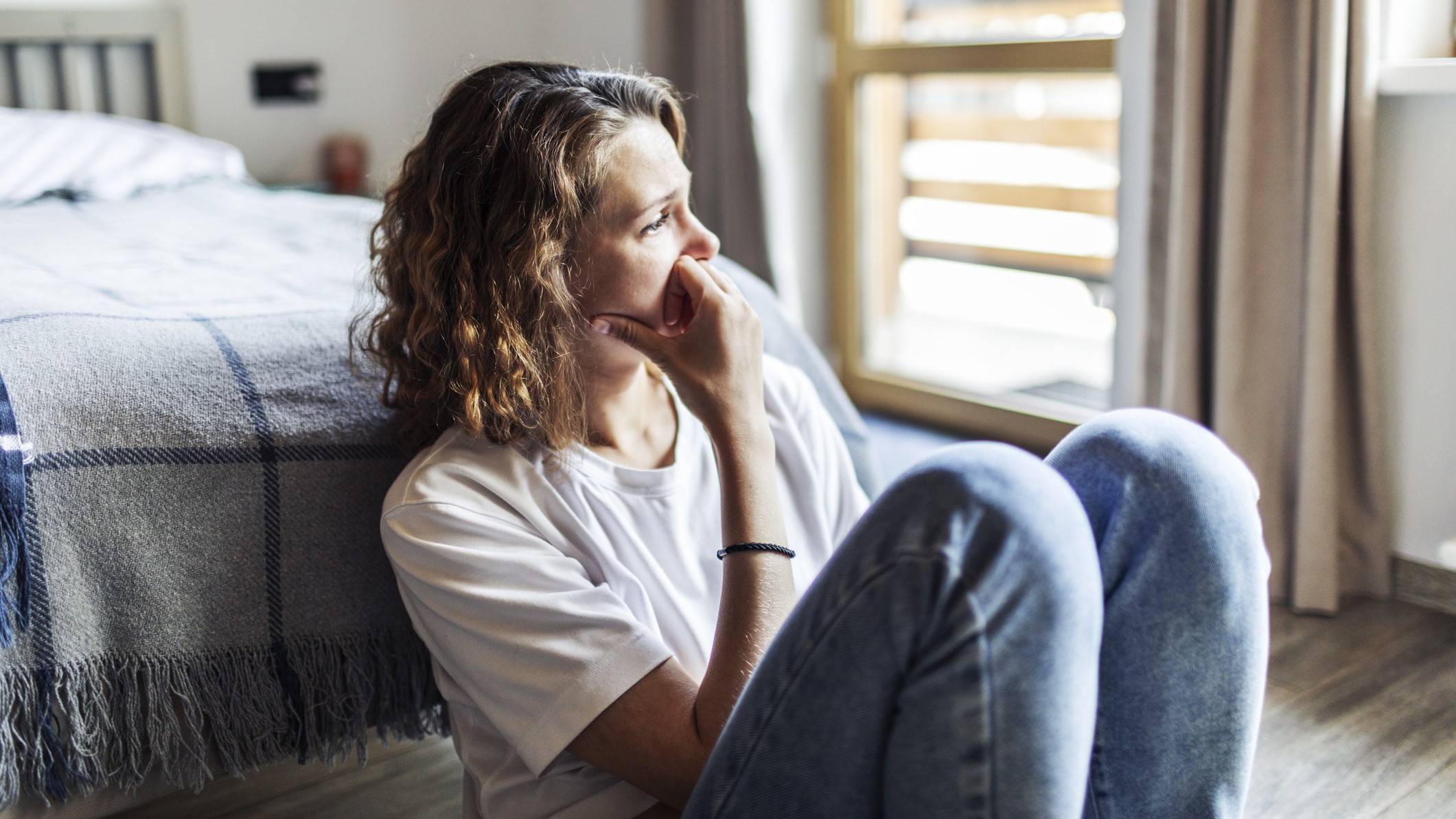 Egy depressziós fiatal felnőtt nő, aki egyedül ül otthon