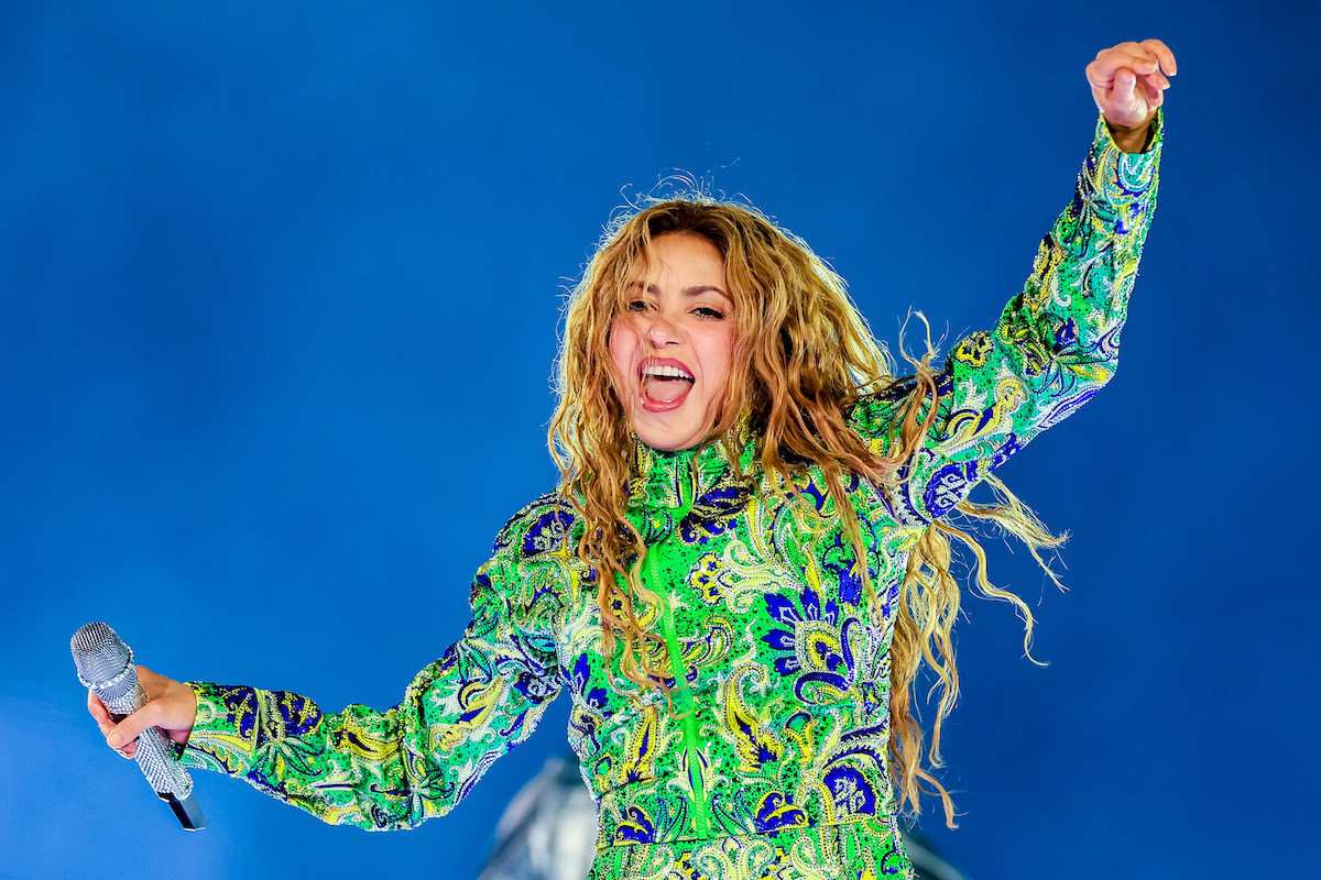 foci-vb-2026-shakira | Marie Claire Shakira zöld ruhában táncol, kék háttér előtt