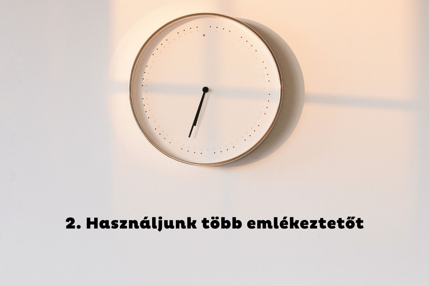 Óra reggeli fényben a fehér falon
