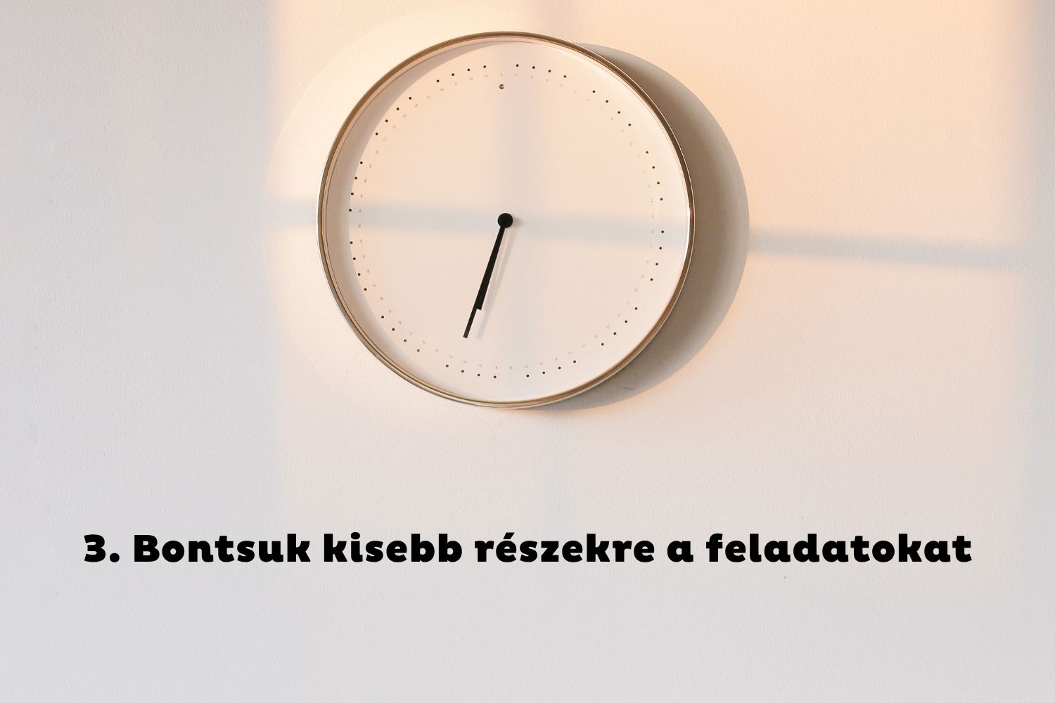 Óra reggeli fényben a fehér falon