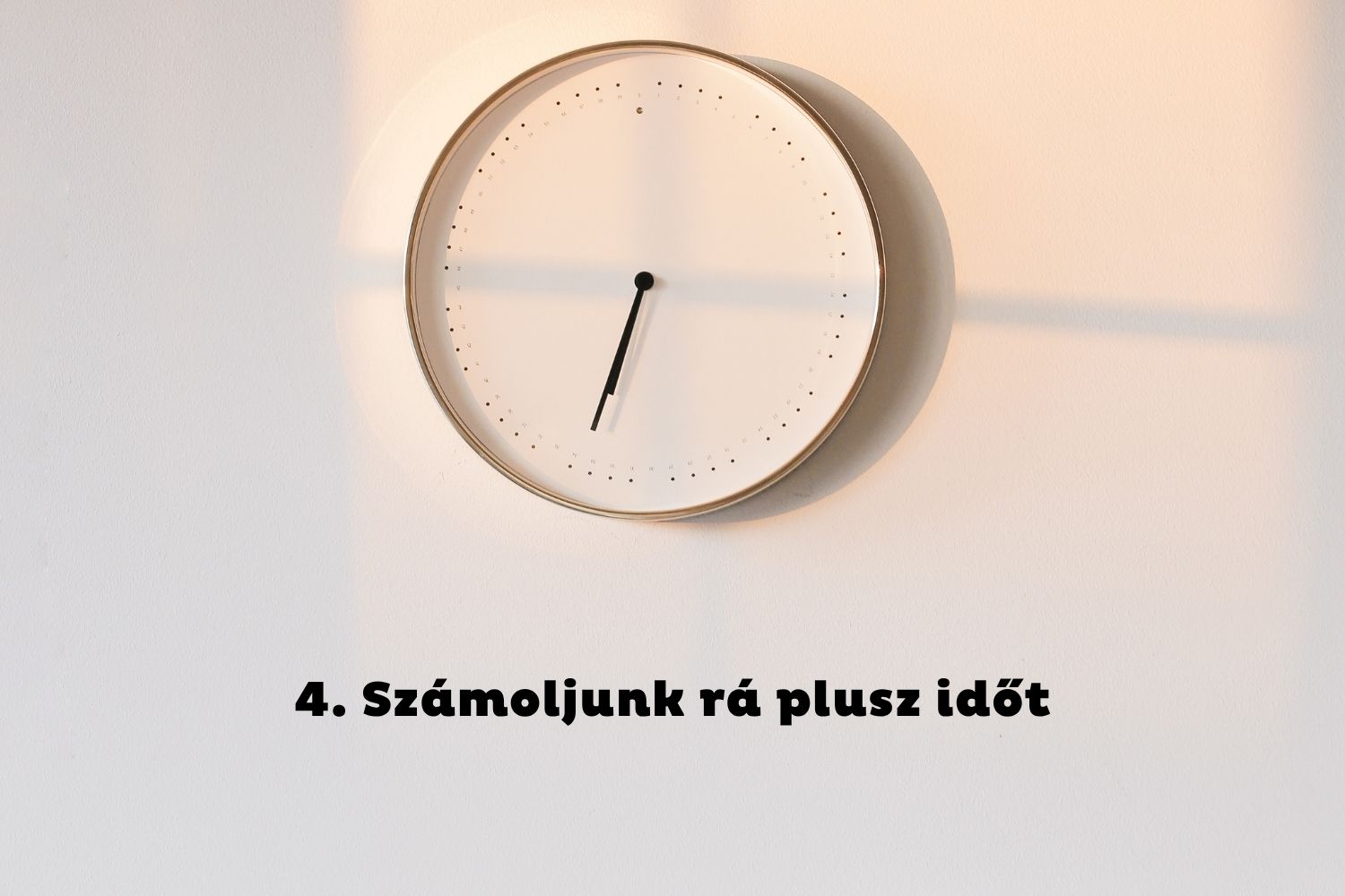Óra reggeli fényben a fehér falon