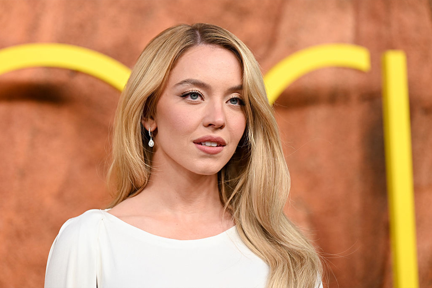 Sydney Sweeney fehér ruhában az HBO Eufória 3. évadának premierjén a TCL Chinese Theatre-ben, 2026. április 7-én, Los Angelesben, Kaliforniában. Megjegyzés: Canva kép