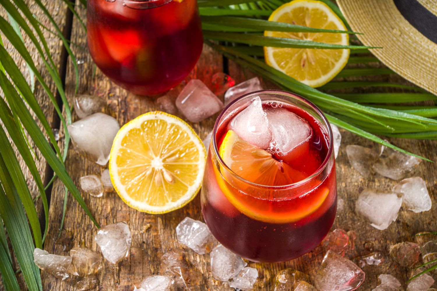 Tinto de verano spanyol nyári vörösboros koktél üvegpohárban citromkarikával, körülötte jégkockák