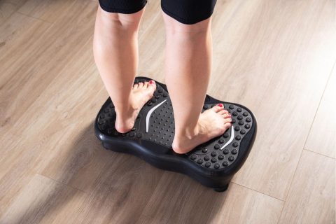Nő lába vibrációs tréning eszközön állva