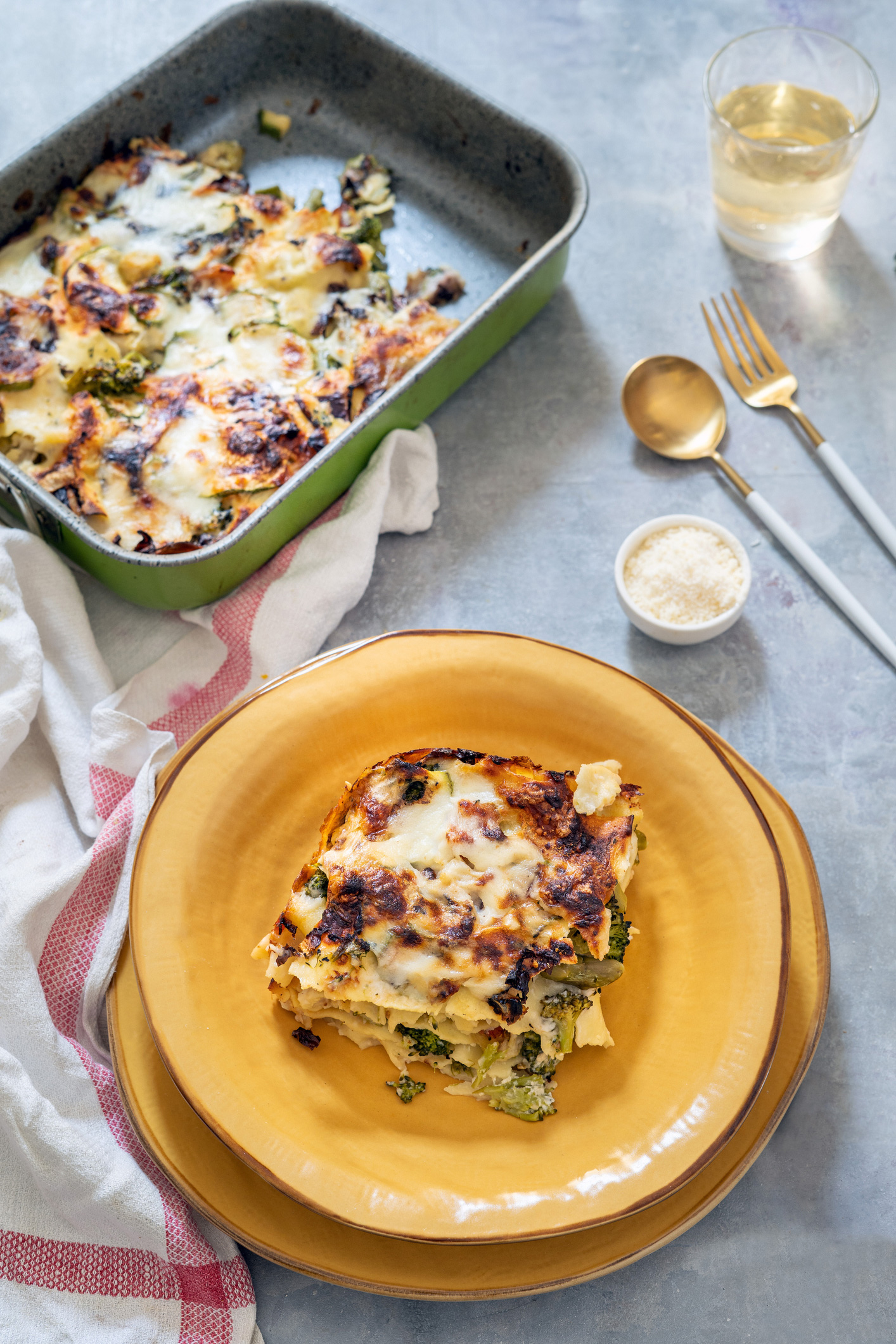 Zöldséges lasagne egy barna tányéron 