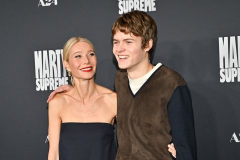 Gwyneth Paltrow fekete váll nélküli felsőben és Moses Martin pulóverben, nevetve