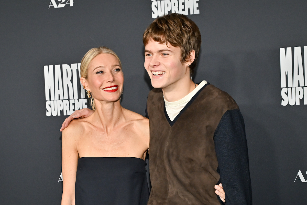Gwyneth Paltrow fekete váll nélküli felsőben és Moses Martin pulóverben, nevetve