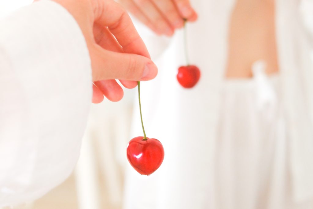 oralis-szex-noknek-tippek | Marie Claire Női kéz egy cseresznyét tart a kezében a fehérneműs tükörképe előtt