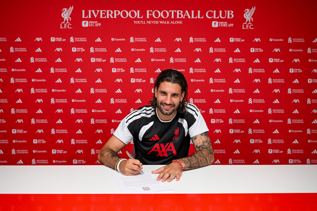 Szoboszlai Dominik piros Liverpool FC háttér előtt szerződést ír alá