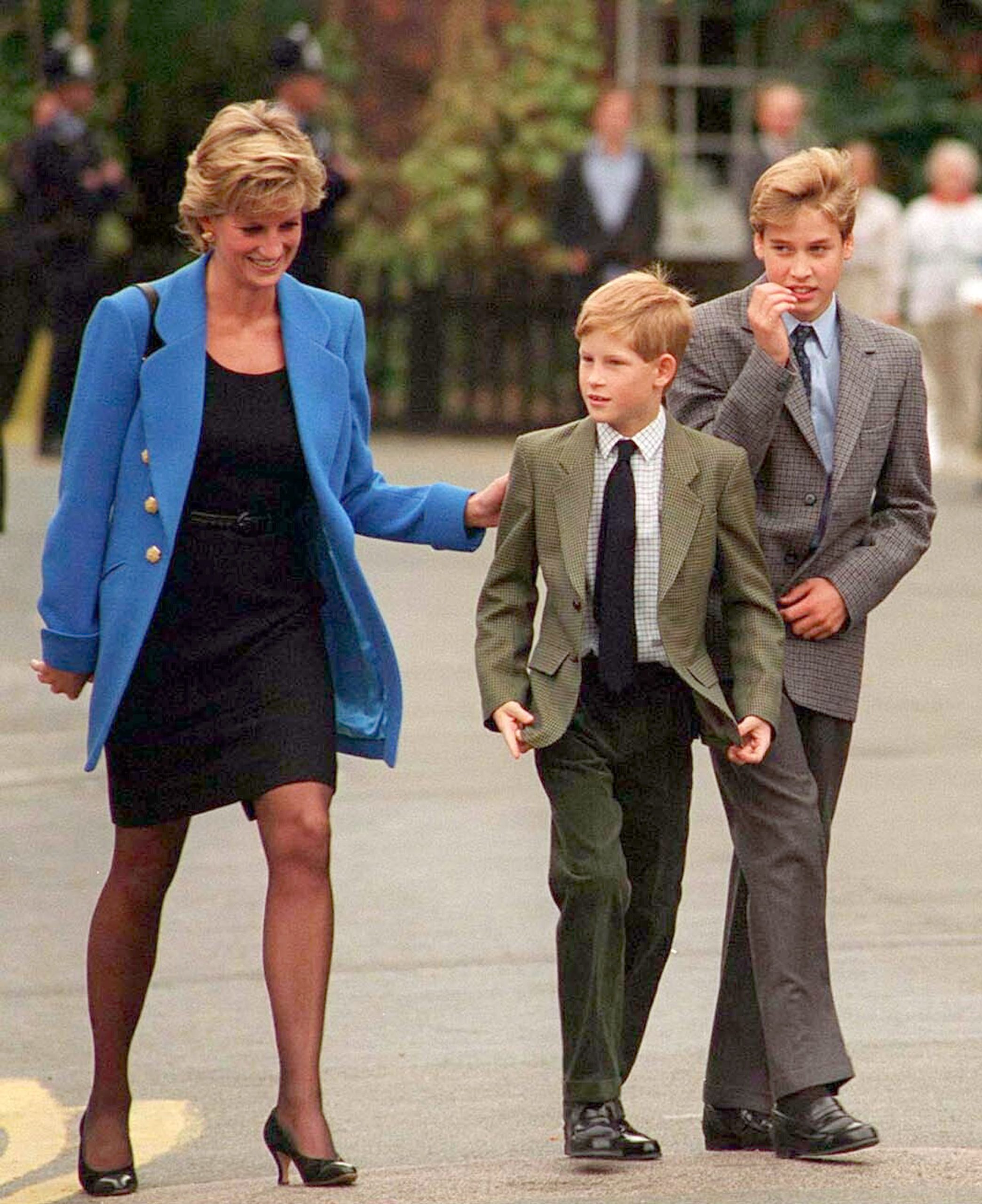 diana-karoly-kiraly-harry-herceg-highgrove | Marie Claire Diana kék blézerben, mellette Harry és Vilmos, egész alakos kép