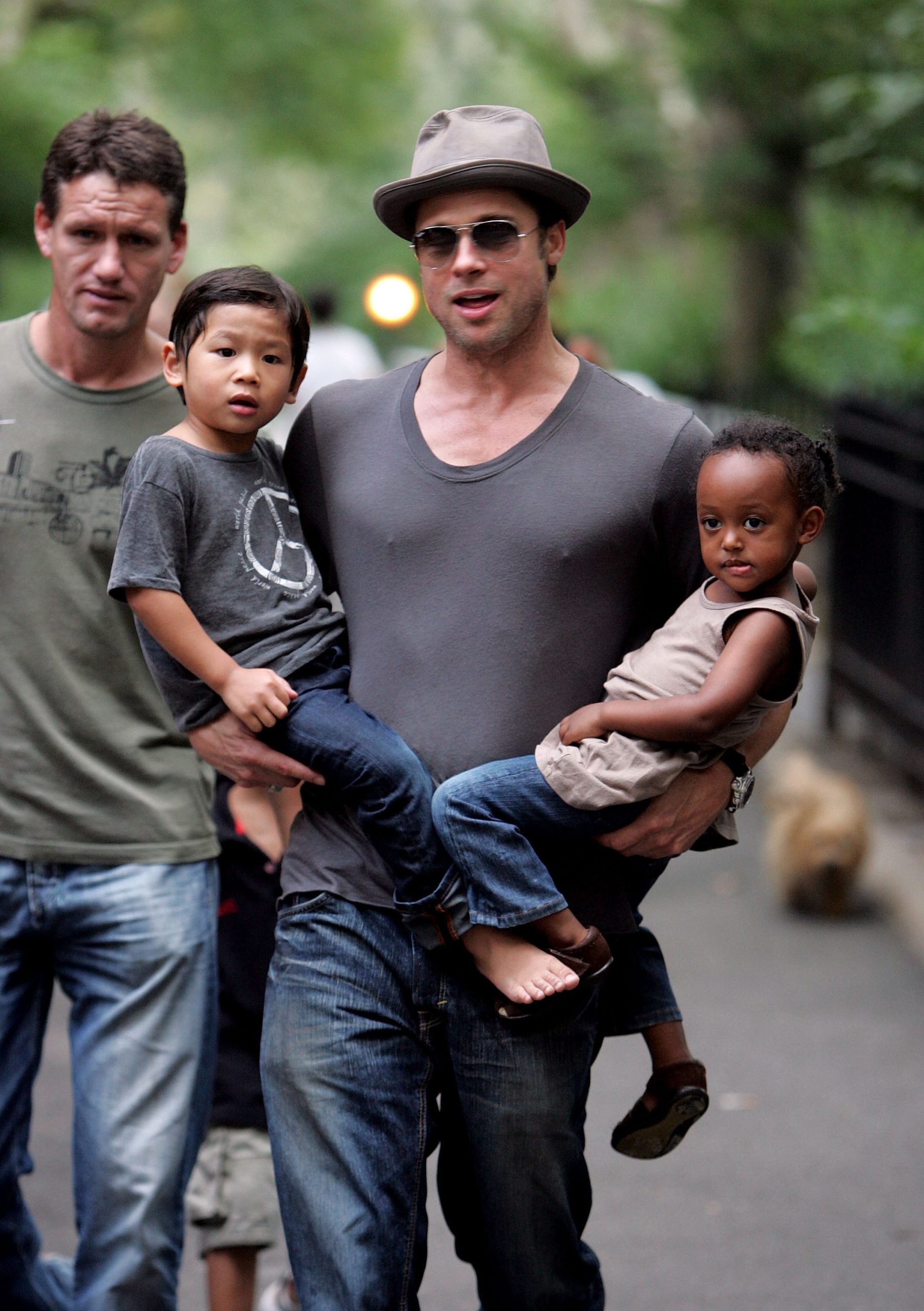 brad-pitt-zahara-maddox-nev | Marie Claire Brad Pitt szürke pólóban és kalapban, a kezében kisgyerekek
