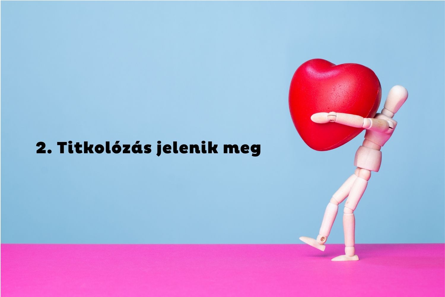 Kék-rózsaszín háttér, anatómiai fabábu piros szívet cipel