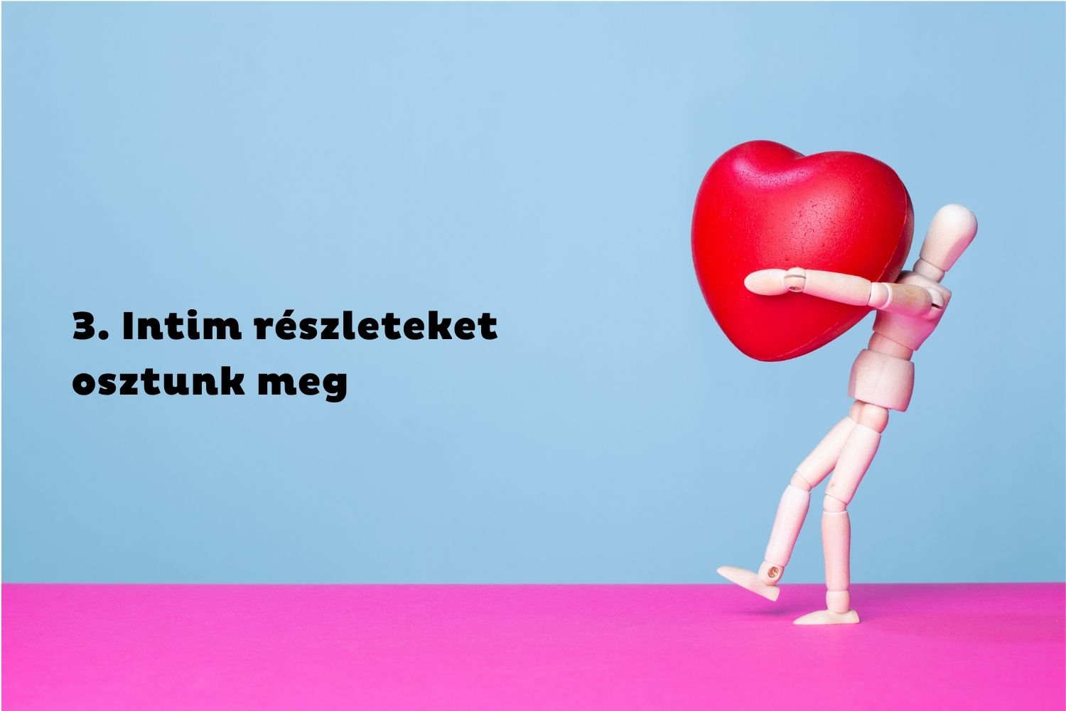 Kék-rózsaszín háttér, anatómiai fabábu piros szívet cipel