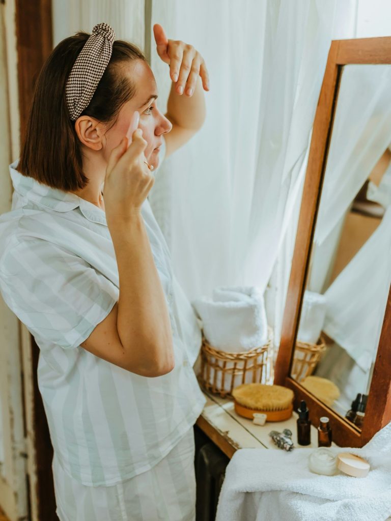egyszeru-arcapolasi-rutin | Marie Claire Nő arcápolási rutin közben tükör előtt állva
