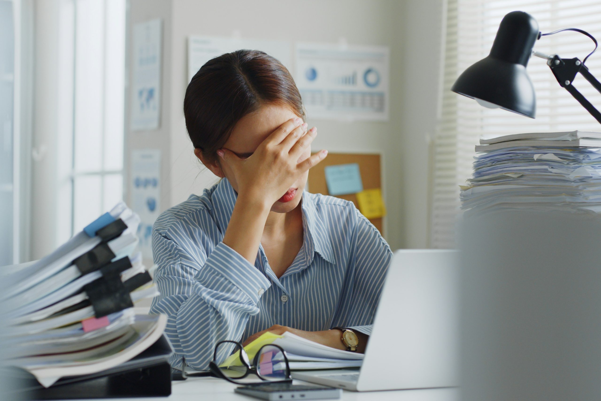 Egy stresszes nő fogja a fejét