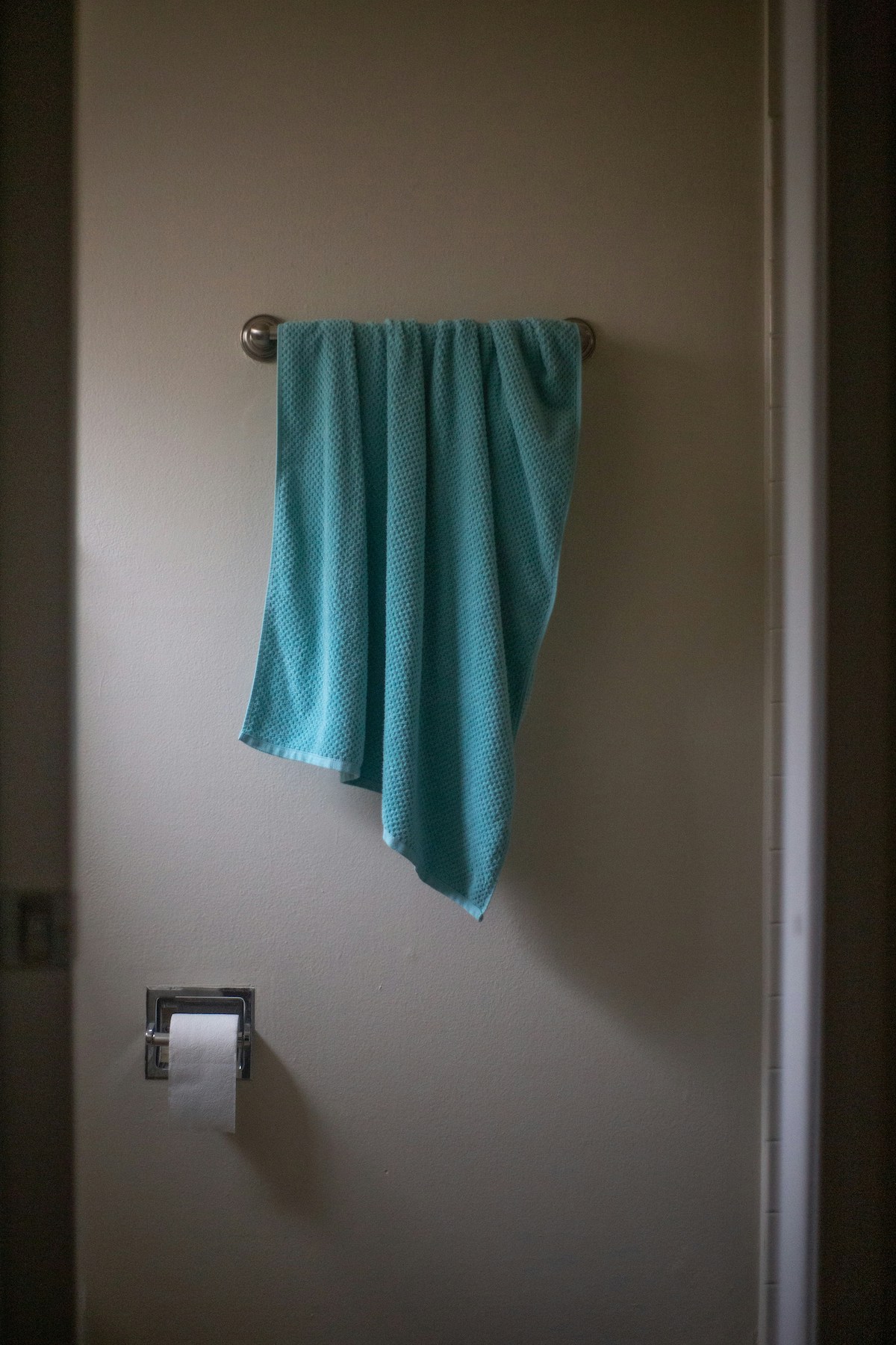törölközőtartón kék törölköző, a falon wc-papír tartó