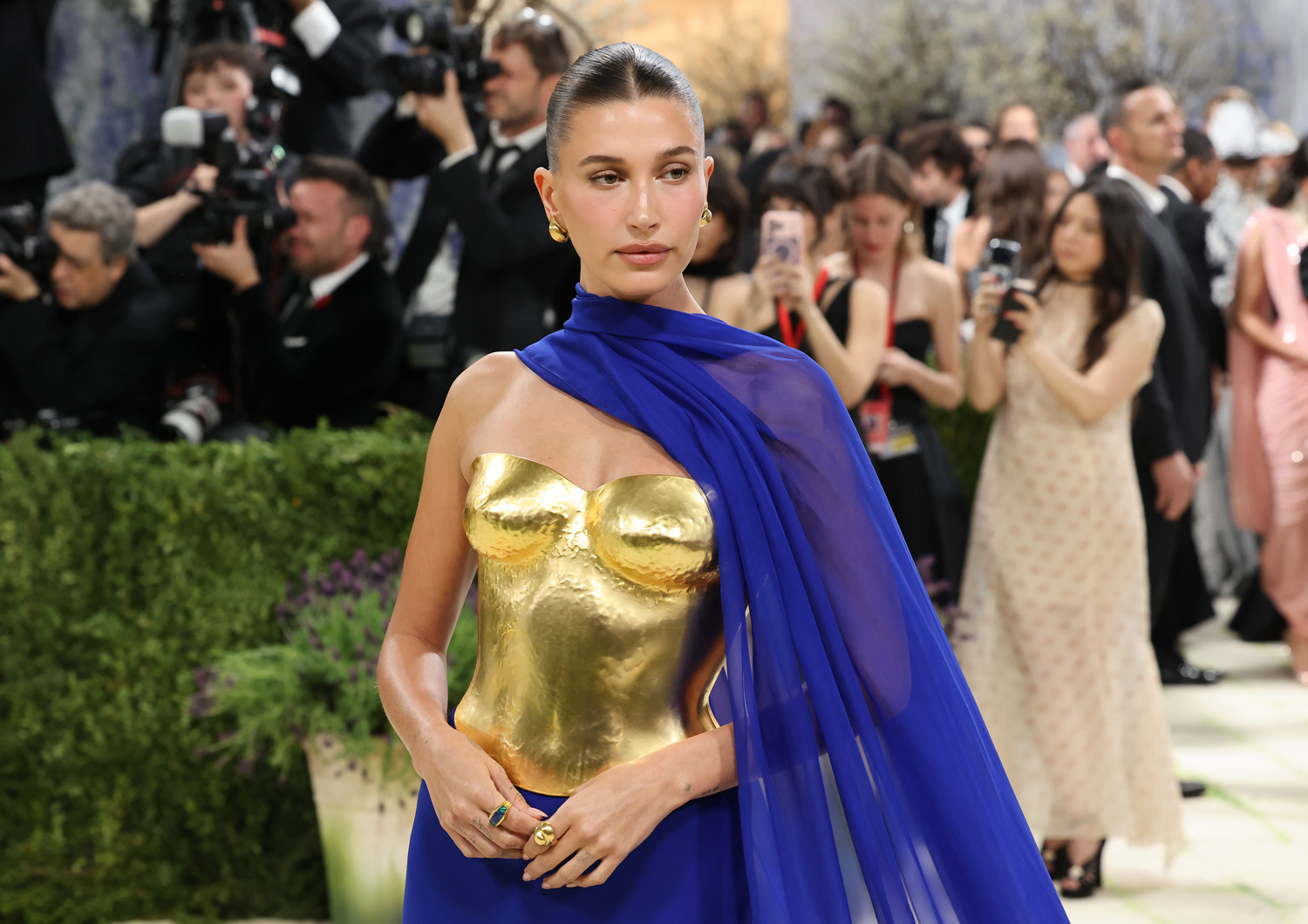 Hailey Bieber arany színű ruhában, kék sállal a 2026-os Met-gálán
