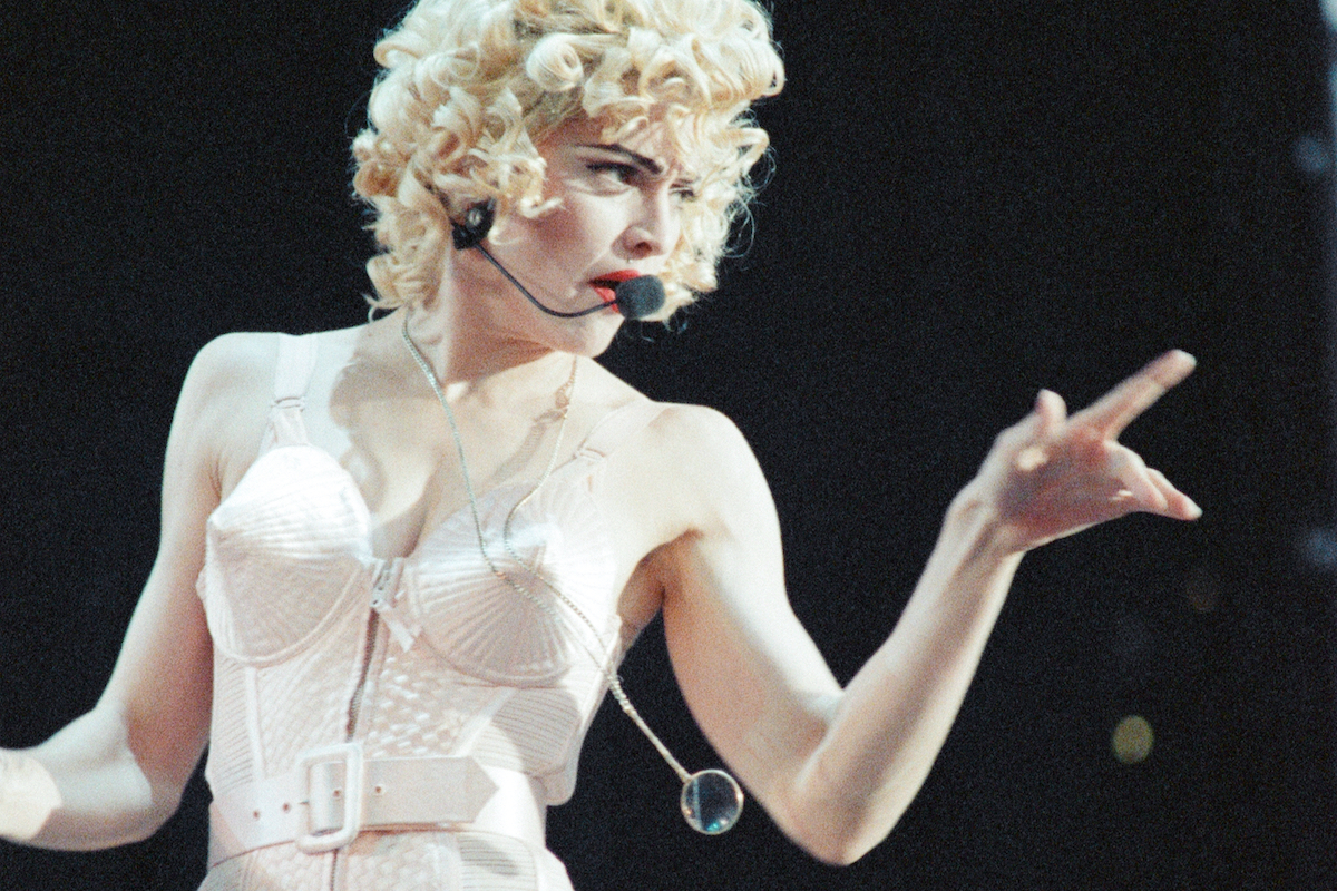 Madonna a híres fehér kúpmelltartóban énekel, mikrofonnal a fején