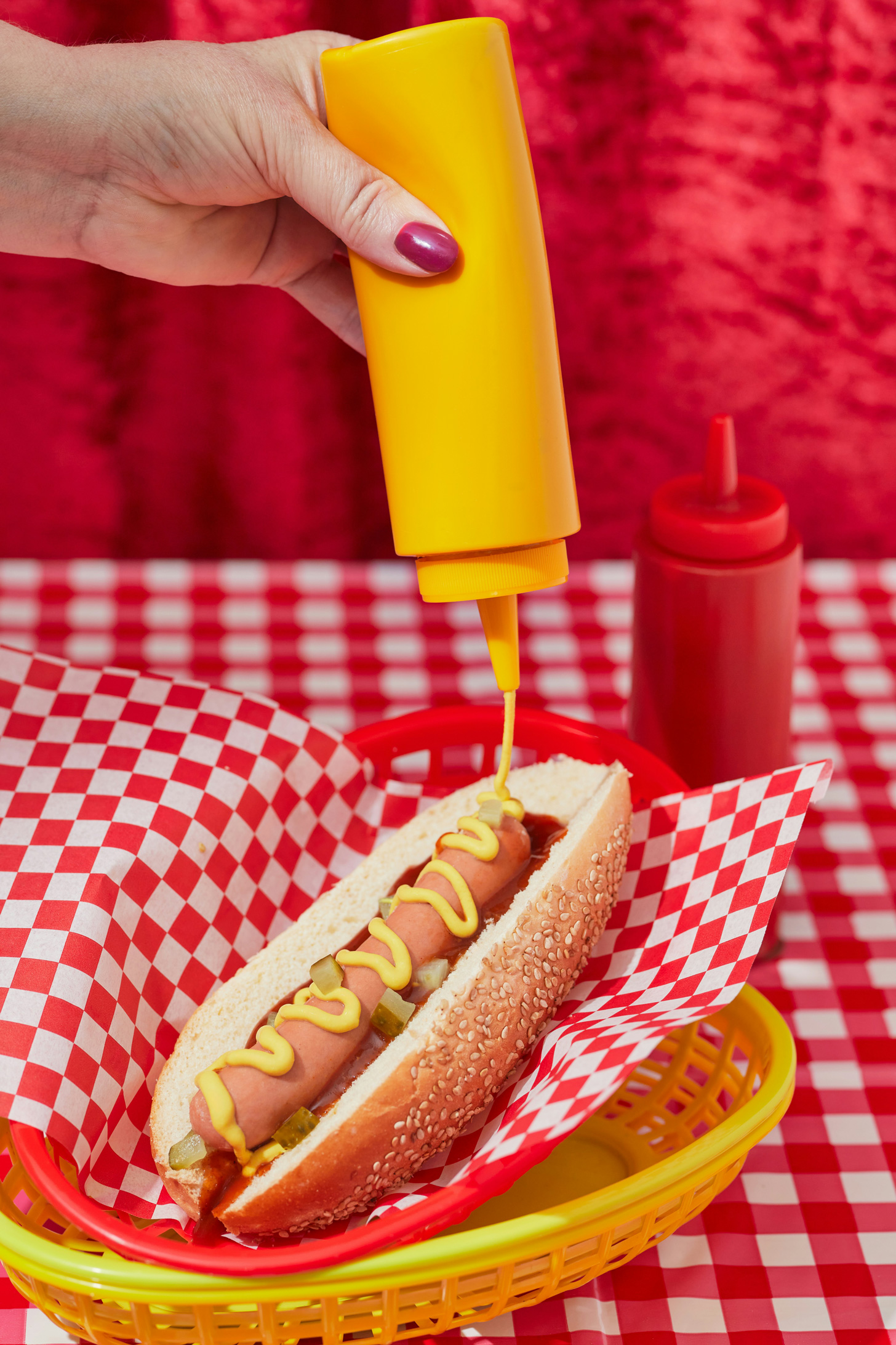 feldolgozott-husok-cukros-uditok-rak | Marie Claire Egy nő mustárt nyom a hot dogjára