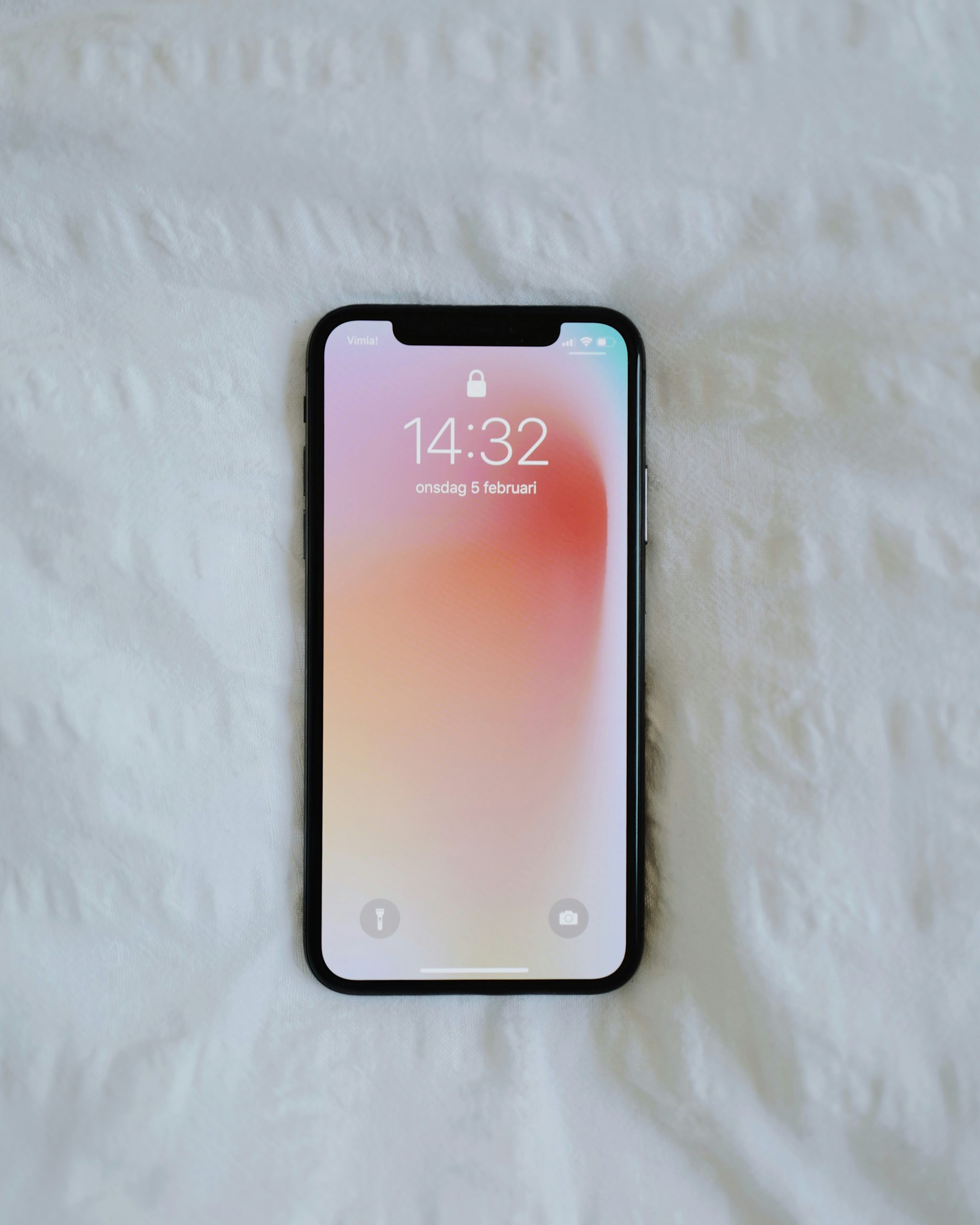 fehér háttér előtt mobiltelefon 14:32-kor