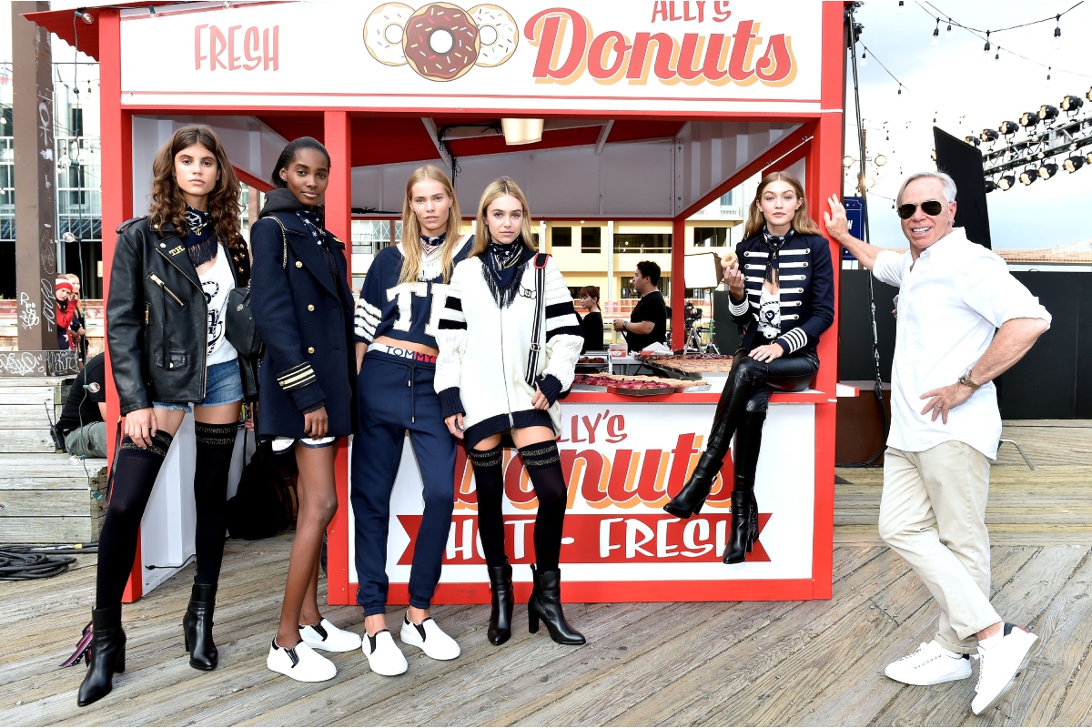 Gigi Hadid modell (jobbról a második) és Tommy Hilfiger divattervező (jobbra) modellekkel pózolnak a #TOMMYNOW női divatbemutatón a New York-i Divathét keretében a Pier 16-nál 2016. szeptember 9-én, New Yorkban.