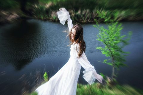Fiatal nő fehér ruhában a parton