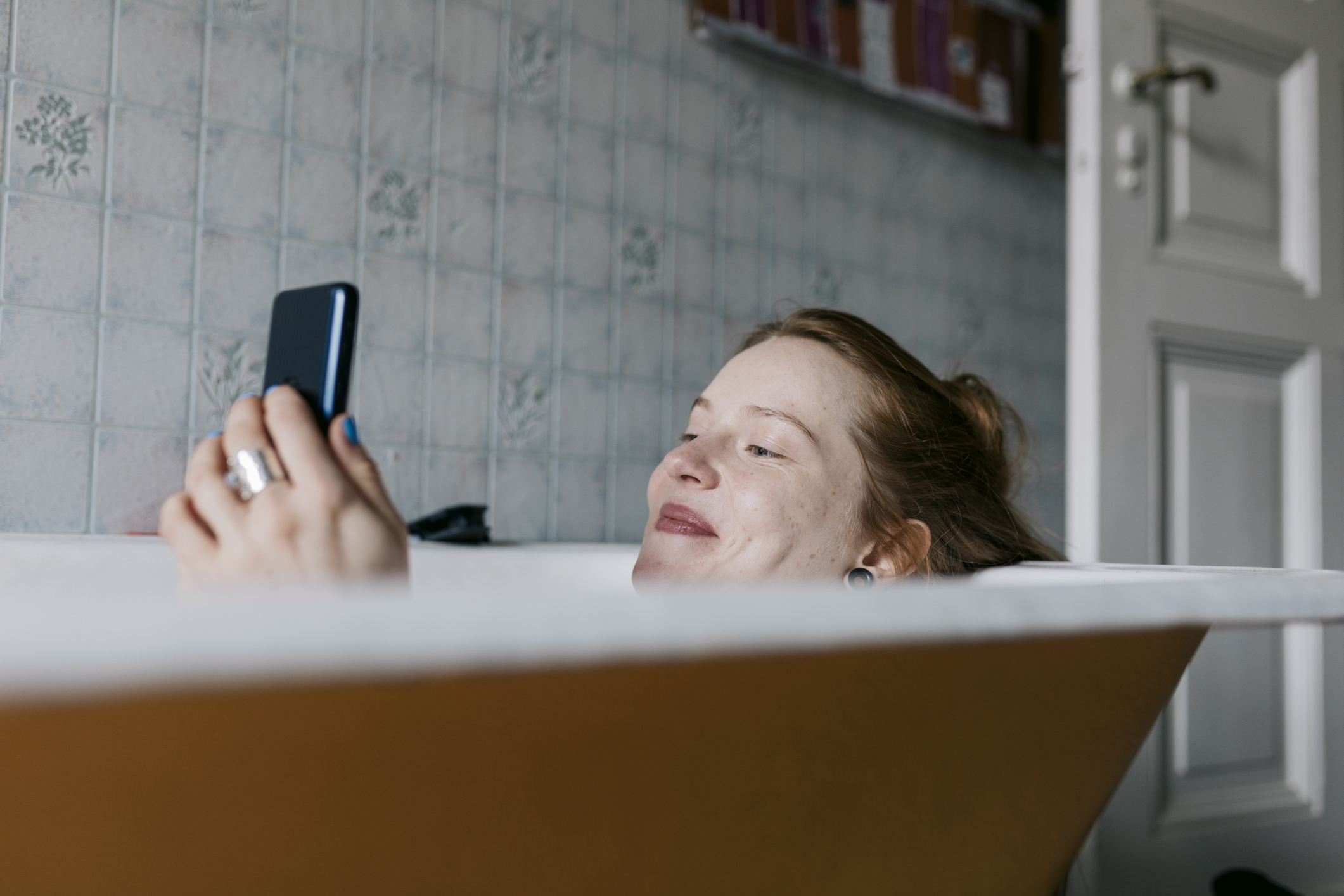 35-evesen-elolrol-valas-utan-tinder-randi | Marie Claire Egy fürdőző nő, aki mosolyog, miközben okostelefonján üzenetet ír valakinek, akivel egy társkereső alkalmazáson ismerkedett meg.