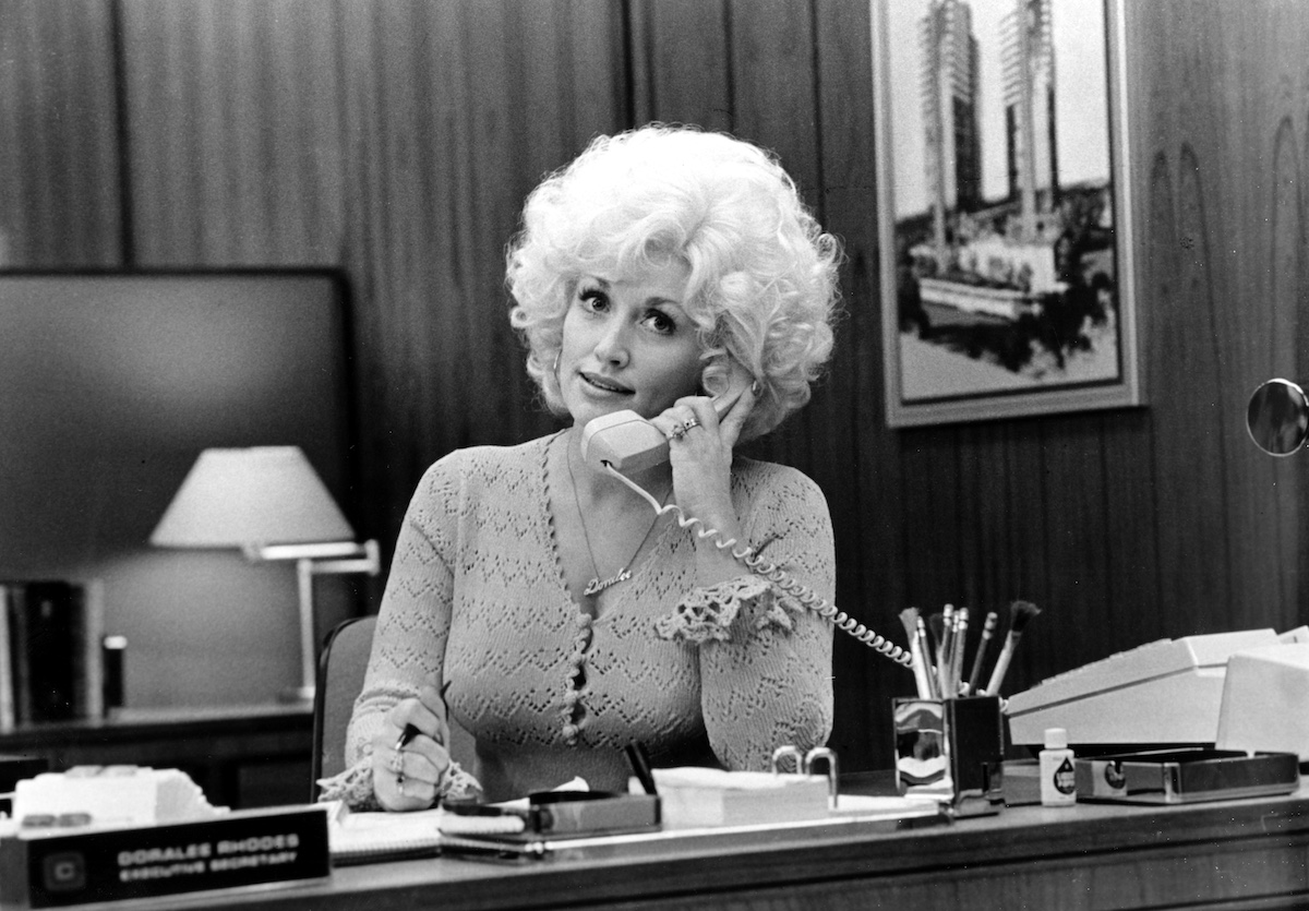 Dolly Parton fekete fehér felvételen ülve telefonál
