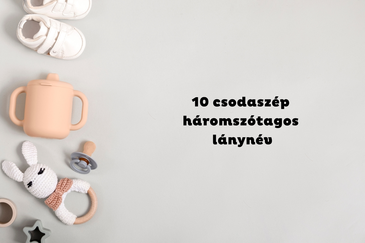 Szürke háttéren oldalt fehér babacipő, rózsaszín ivópohár, cumi és csörgő