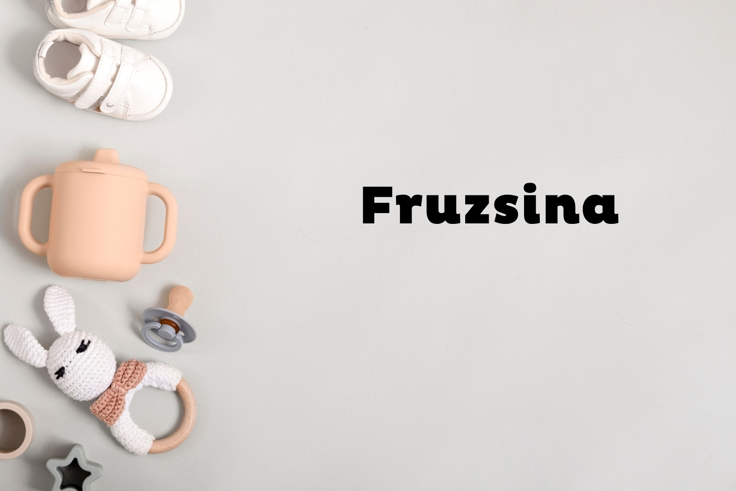 Fruzsina | Marie Claire Szürke háttéren oldalt fehér babacipő, rózsaszín ivópohár, cumi és csörgő