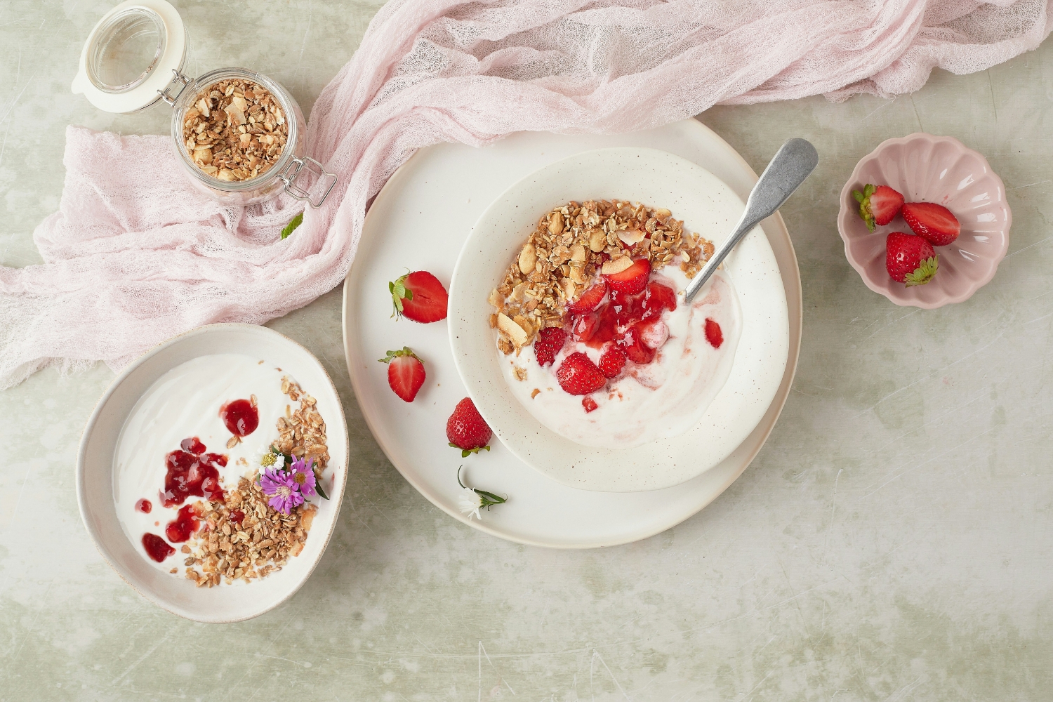 1. Görög joghurt zabpehellyel és bogyós gyümölcsökkel | Marie Claire Márvány asztal, fehér étkészletben görög joghurt müzlivel és piros bogyós gyümölcsökkel