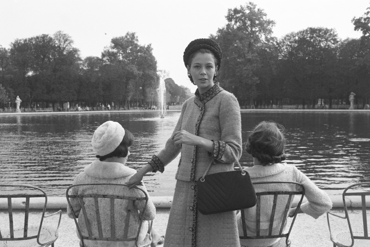 Modell a 2.55-ös táskával és egy Chanel-kosztümmel az 1961–62-es őszi-téli kollekcióból, a párizsi Tuileriák kertjének egyik medencéjénél.
